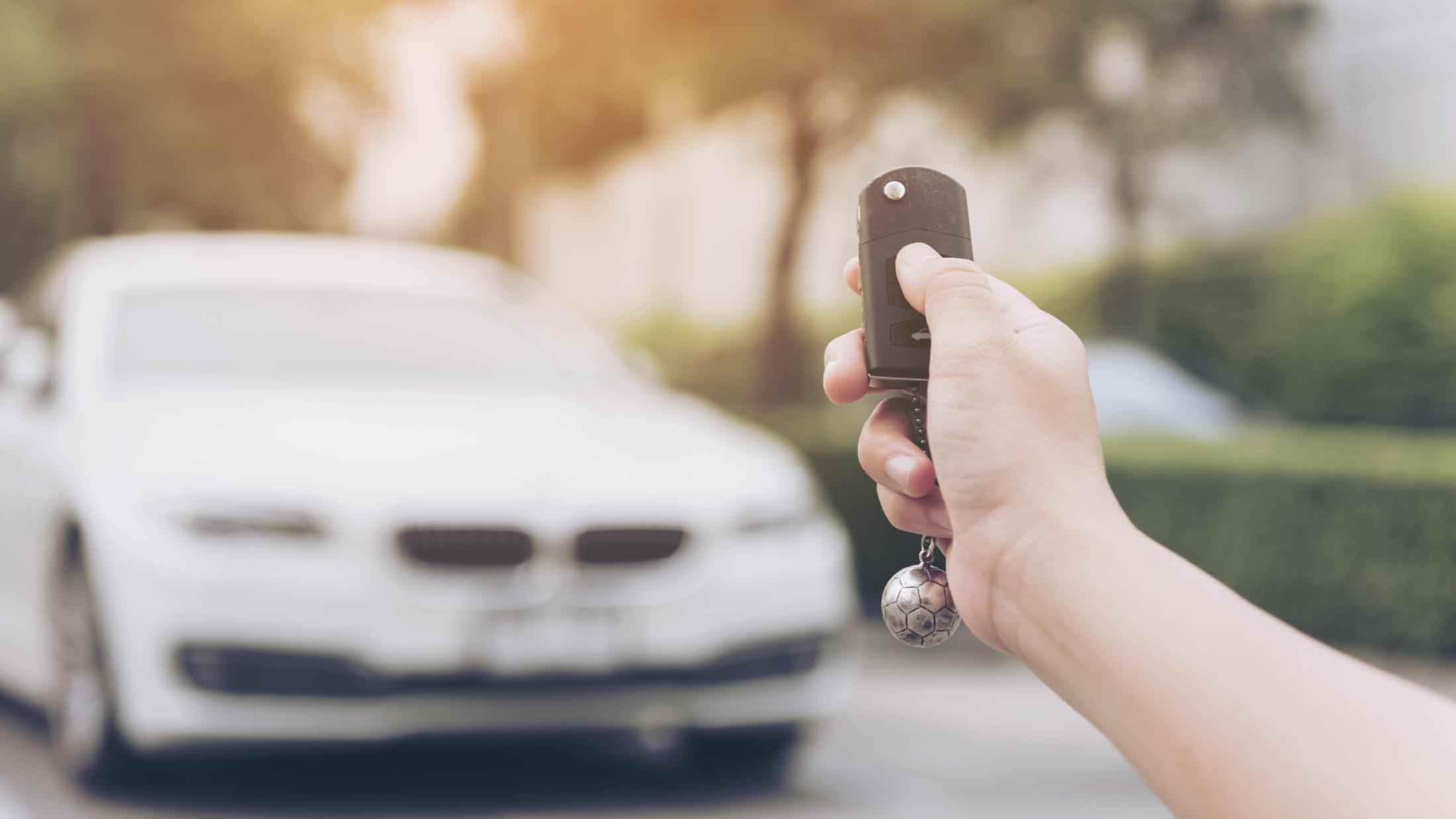 Person pressing unlock button on their cars wireless key fob